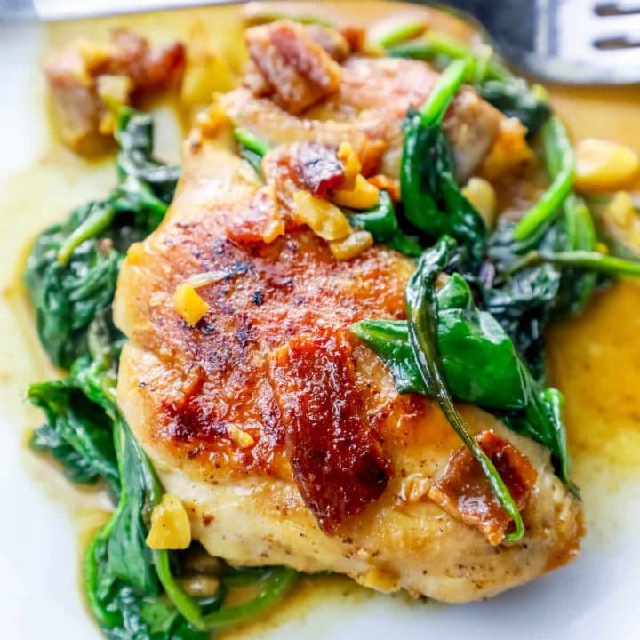 Chicken with spinach and walnuts on a white plate, one pot chicken spinach dinner.