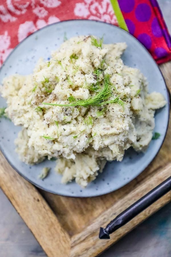 bowl of potatoes with dill on them on a tray