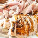 Sliced turkey on a white plate, cooked using the easiest way to cook turkey.