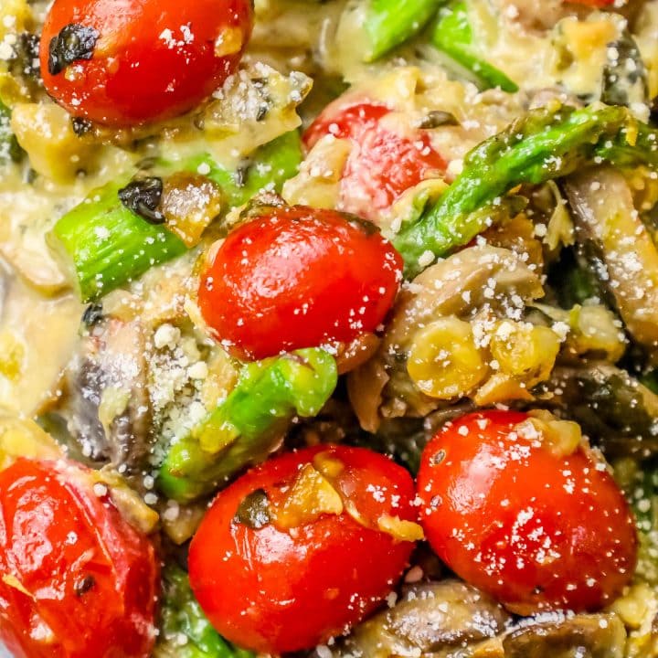 A close up of mushrooms and tomatoes in a white bowl.