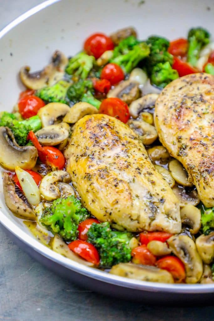 chicken in a bed of broccoli, tomato, and mushrooms and sauce