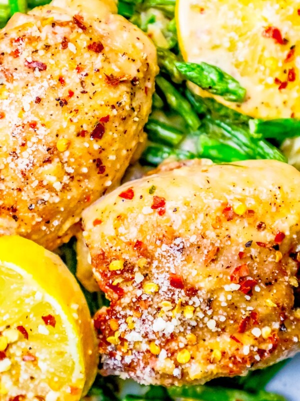 Chicken thighs with asparagus on a plate.