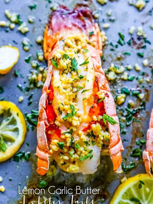 picture of lobster on baking sheet with lemon and parsley on top