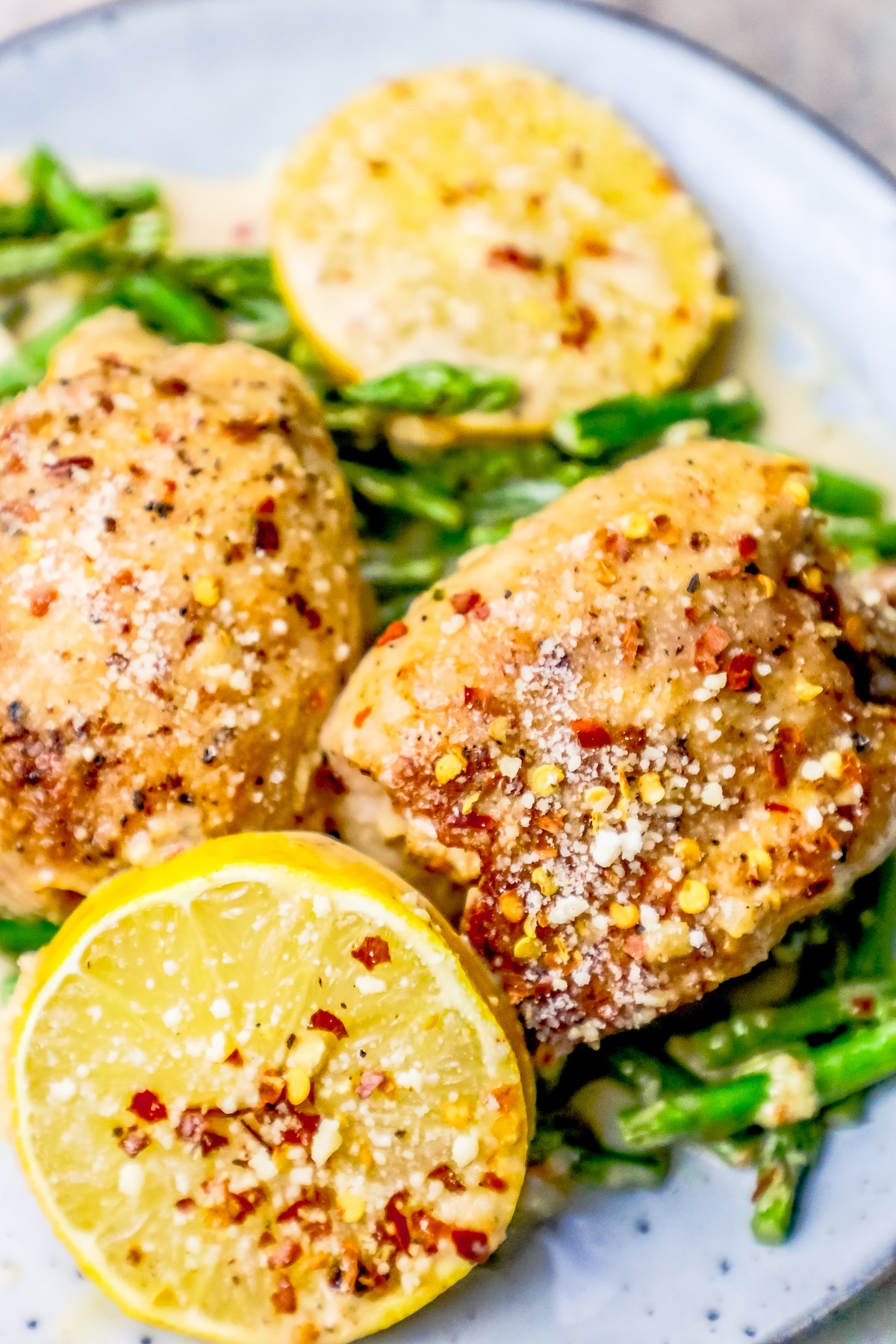 chicken thigh sand lemons on asparagus with seasonings