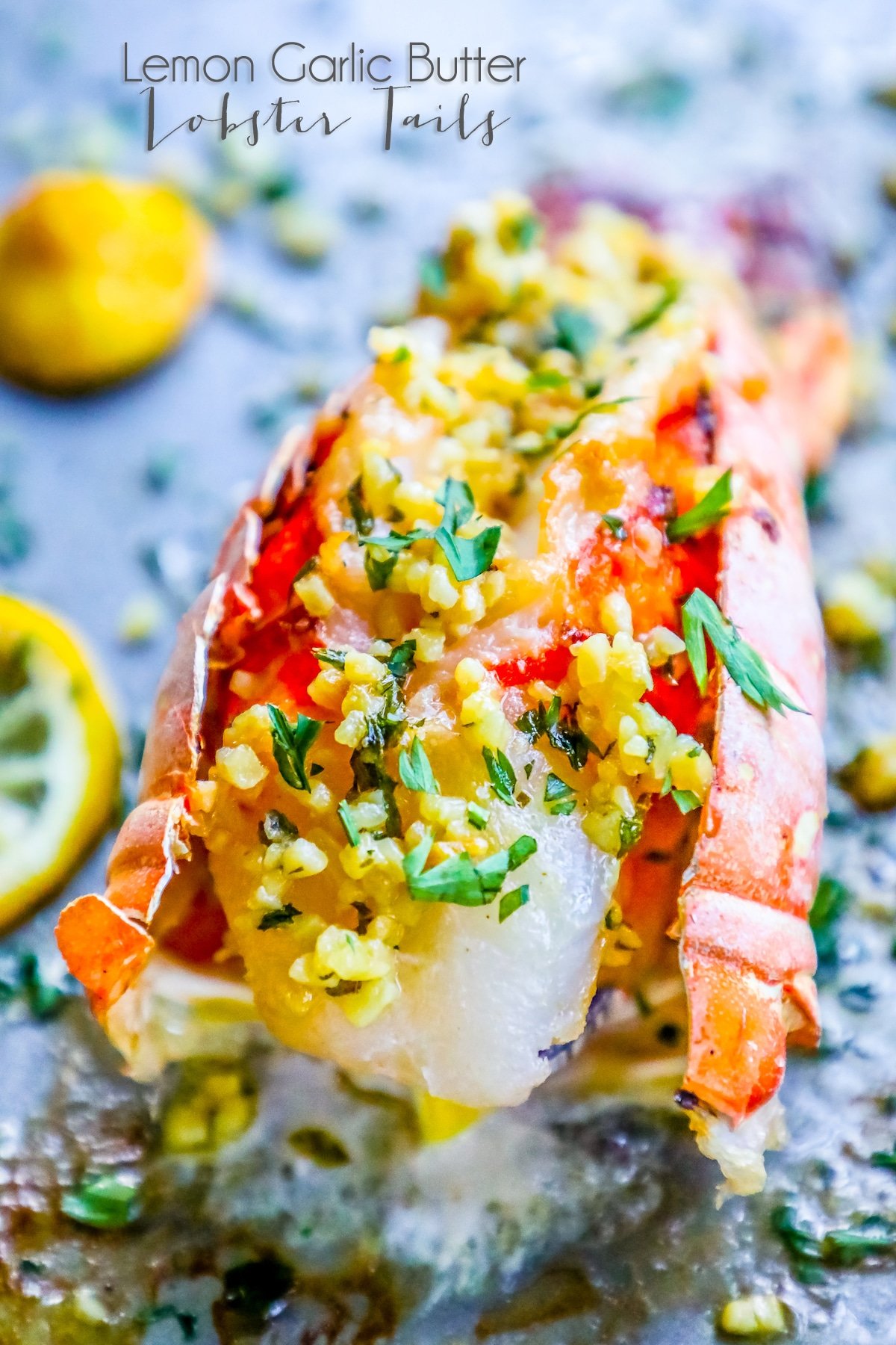 picture of lobster on baking sheet with lemon and parsley on top 