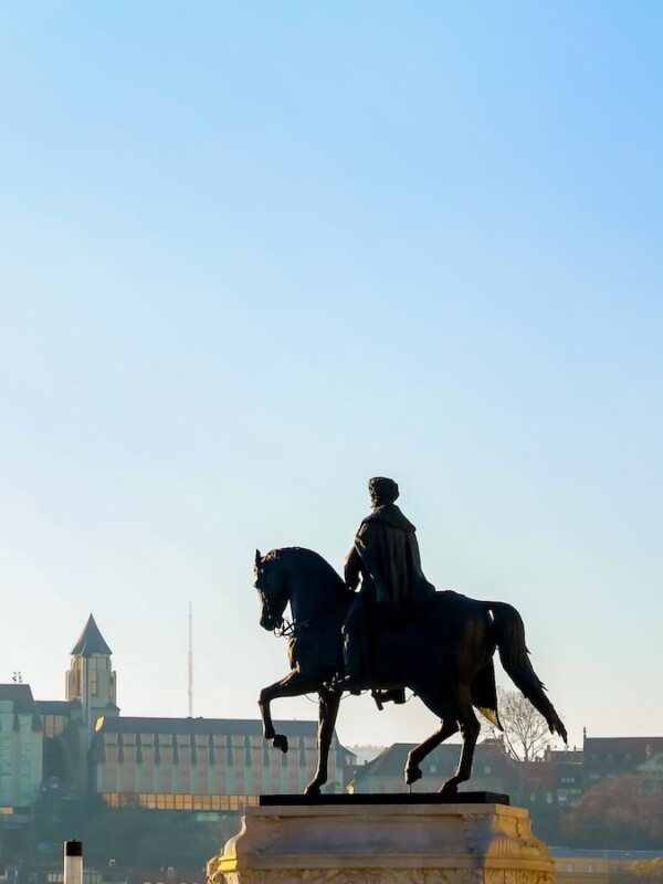 A statue of a man on a horse in front of Budapest, Hungary.