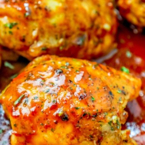 Close up of keto BBQ chicken thighs in a sauce.