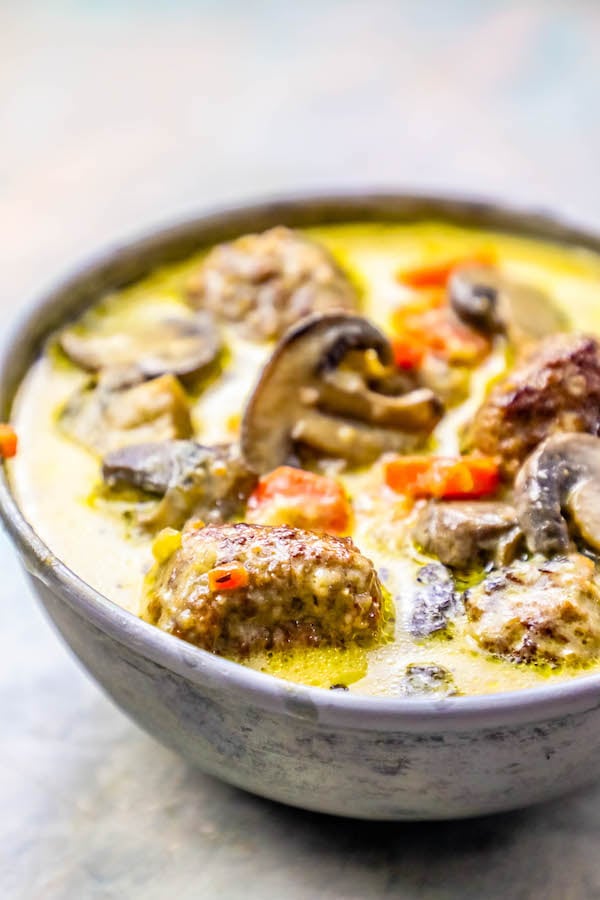 meatballs in a creamy soup with carrot and mushrooms