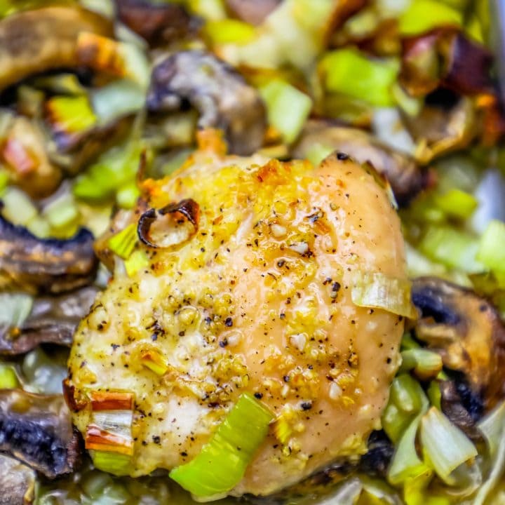 chicken thigh with seasoning, leeks and mushrooms in the background