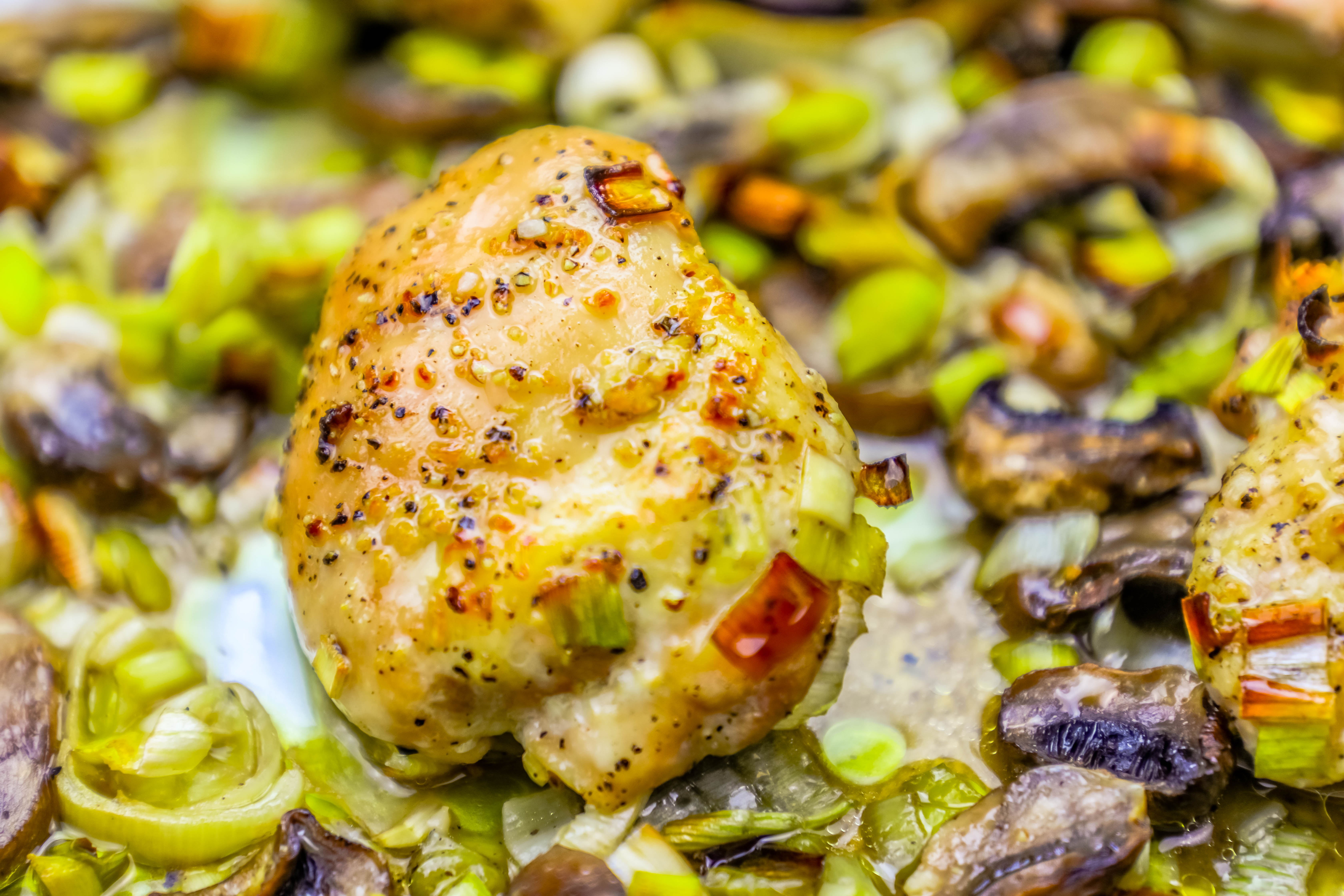 chicken thigh with seasoning, leeks and mushrooms in the background