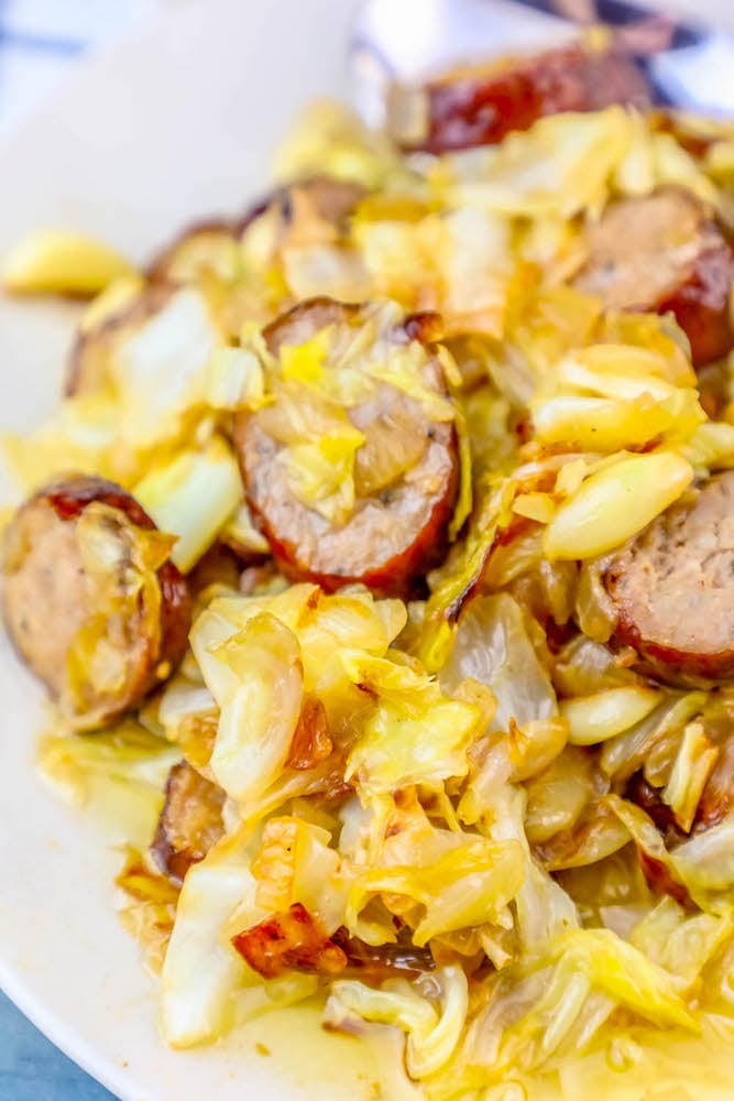 picture of sausage, onions, and cabbage sautéed in a pan 