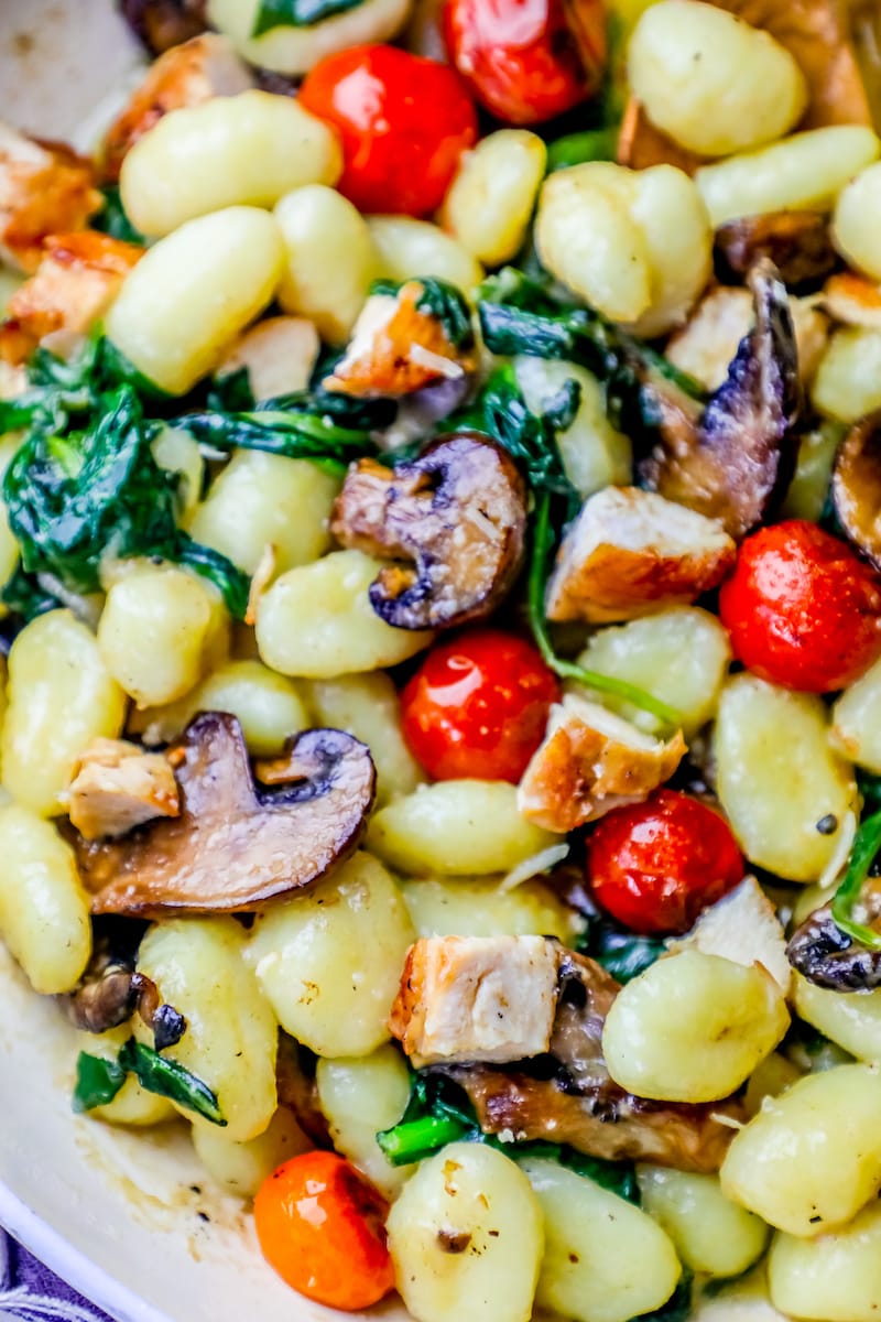 Picture oof gnocchi in pan with tomatoes, chicken, spinach, mushrooms, and cream sauce