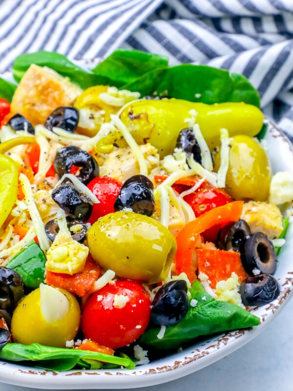 A bowl of Italian chicken salad with olives, tomatoes, and peppers.