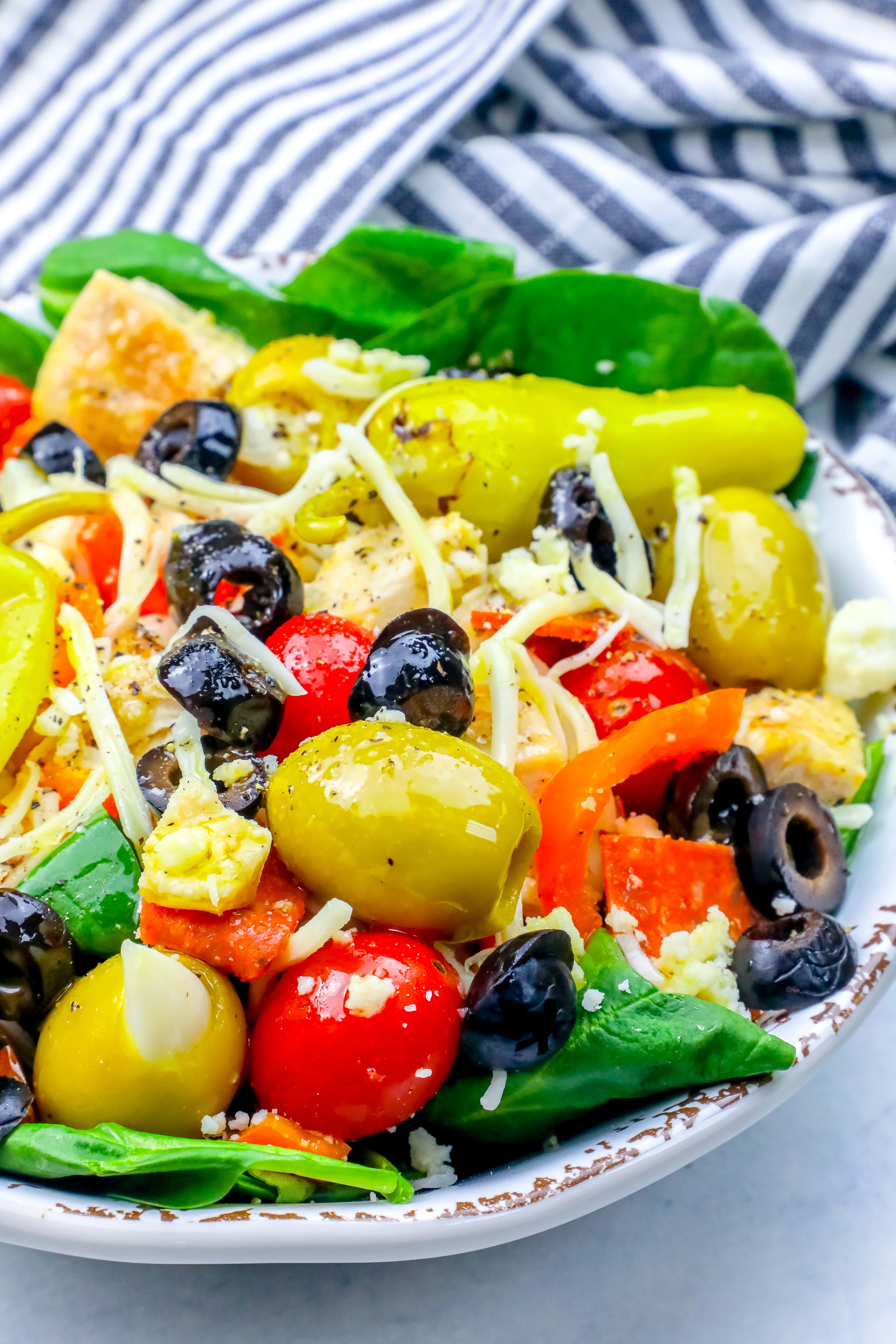 salad with green and black olives, cheese, tomatoes, and pepperoncini peppers