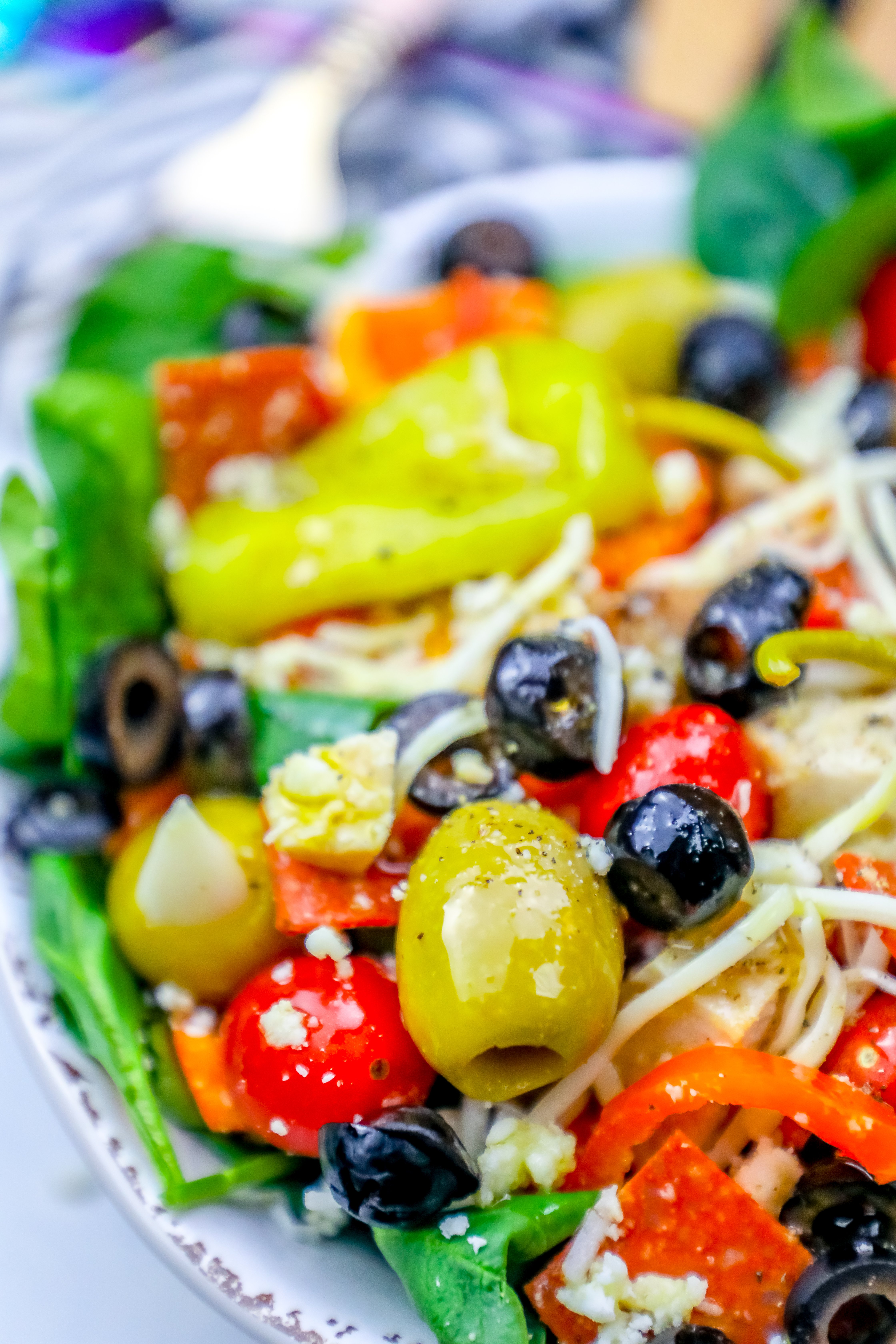 salad with green and black olives, cheese, tomatoes, and pepperoncini peppers