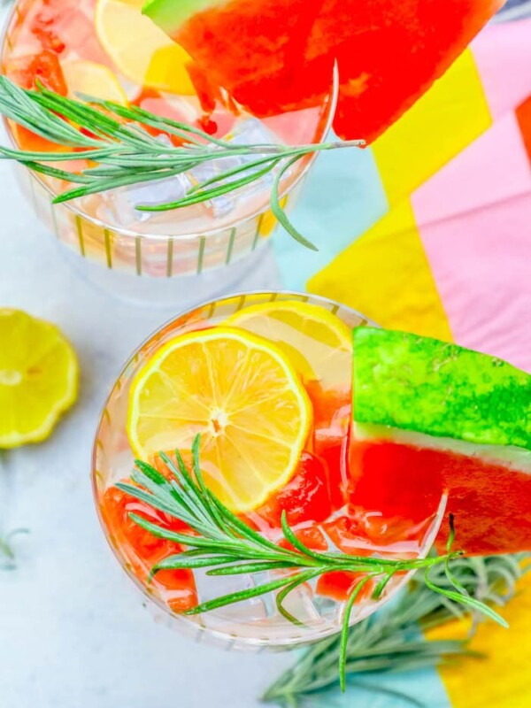 Watermelon lemonade with rosemary sprigs and lemon slices.