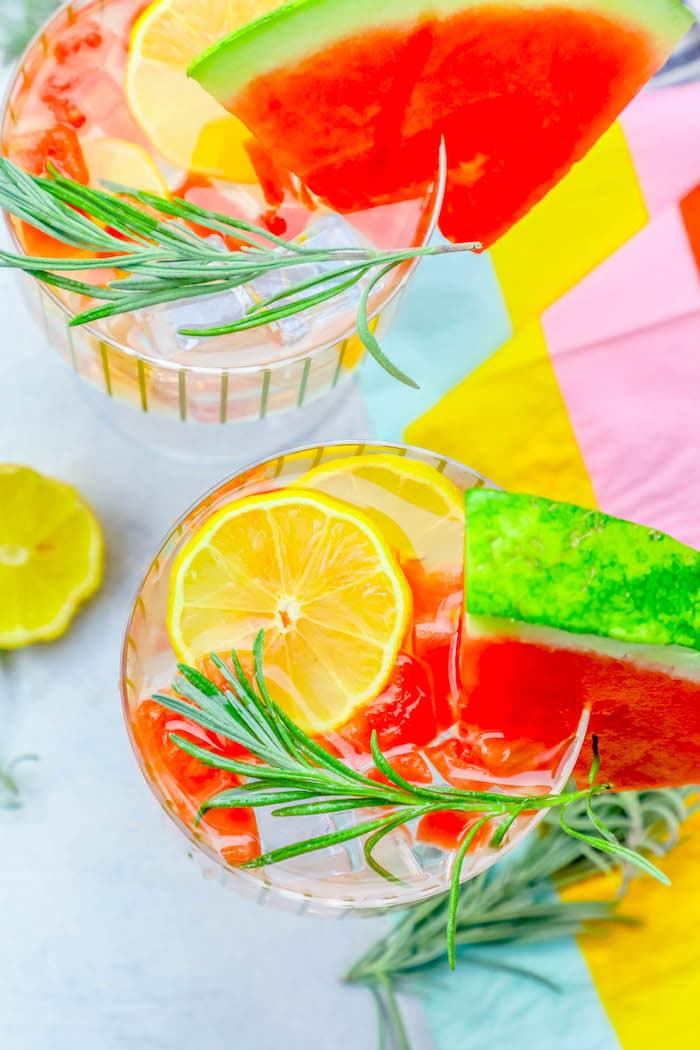 glass with lemon, watermelon, and rosemary in it