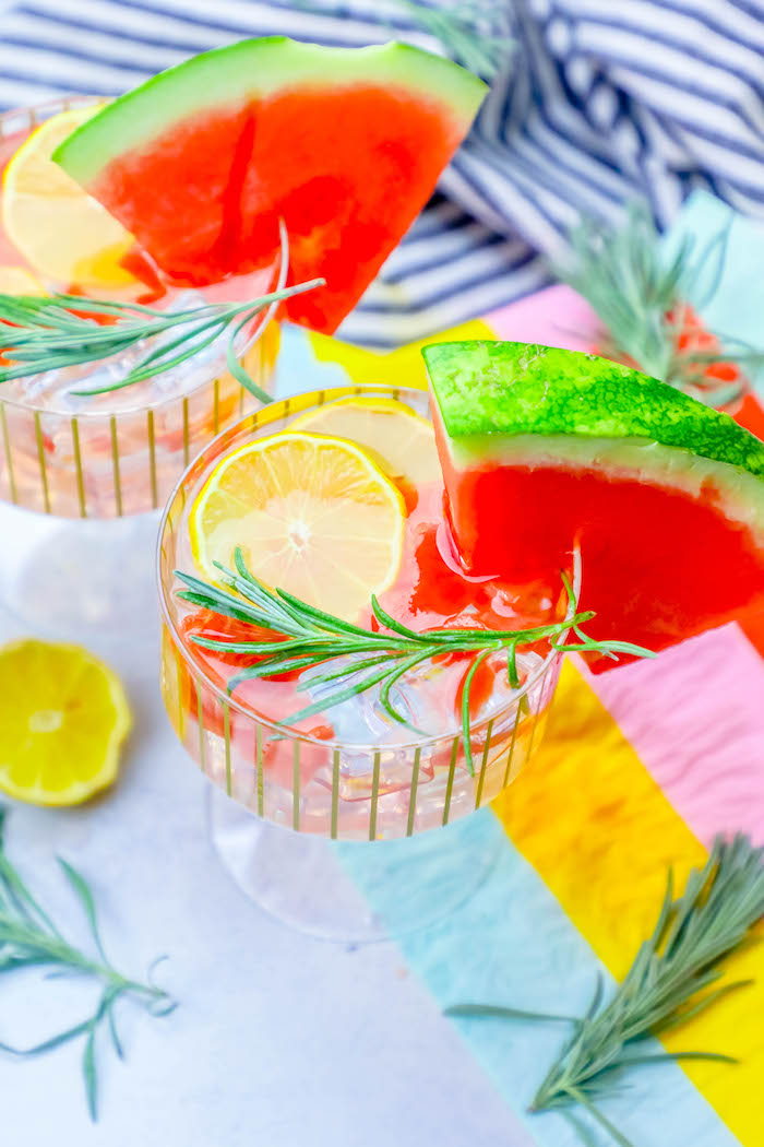 glass with lemon, watermelon, and rosemary in it
