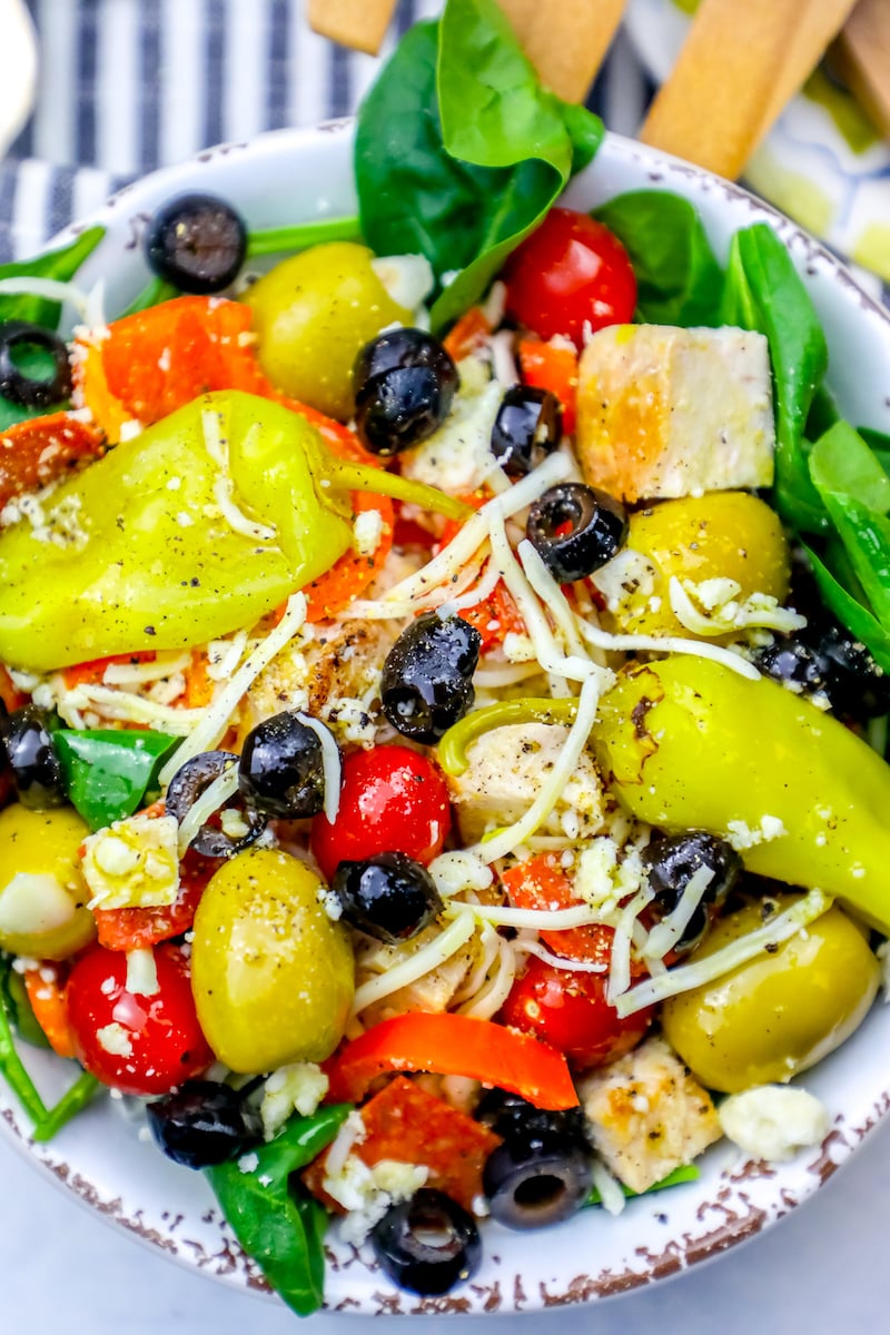 salad with green and black olives, cheese, tomatoes, chicken, and pepperoncini peppers