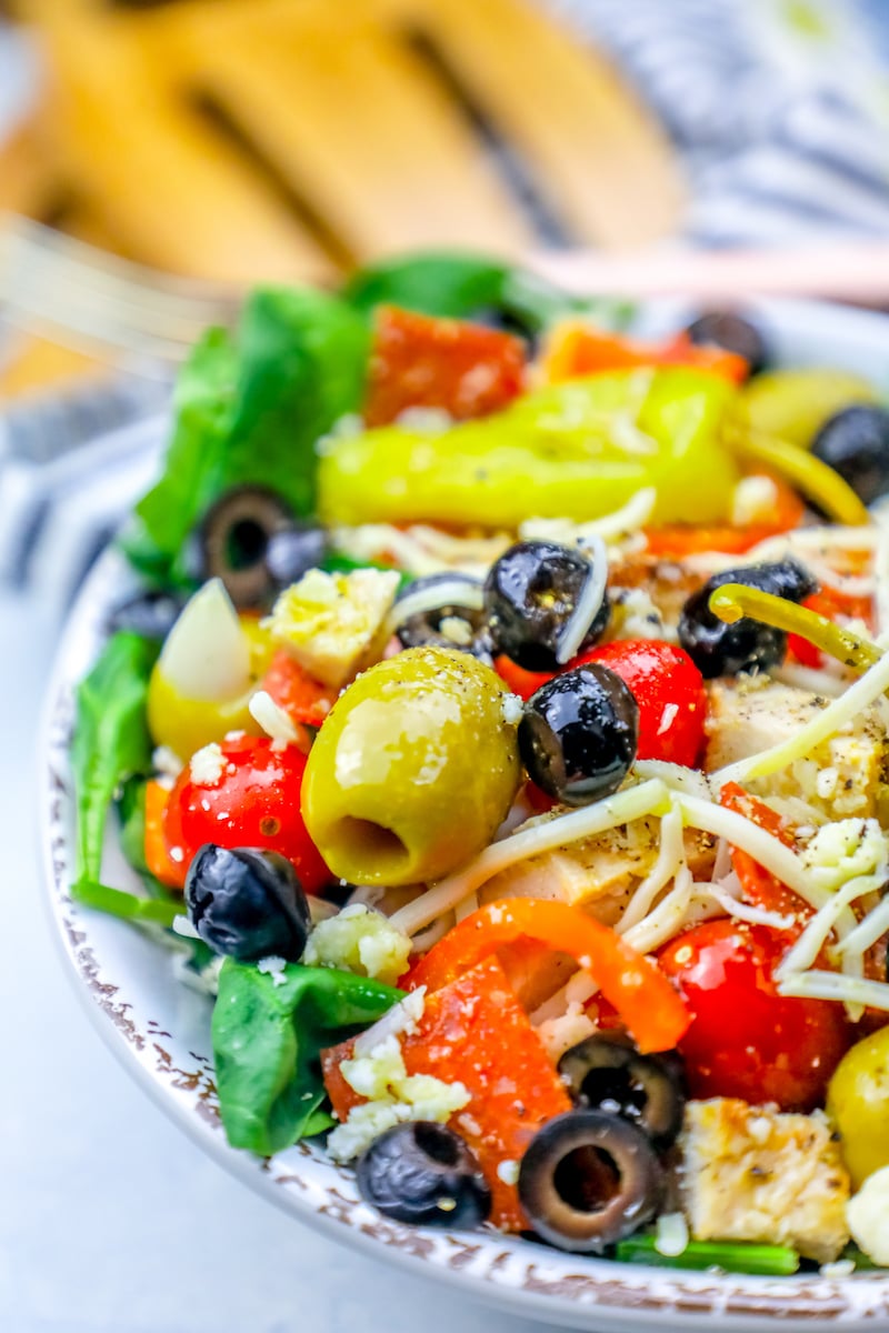 salad with green and black olives, cheese, tomatoes, chicken, and pepperoncini peppers