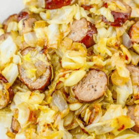 Enjoy the best pan fried cabbage and sausage ever—sliced sausage, cooked cabbage, and onions lightly browned and served together for a delicious keto diet cabbage sausage dinner.