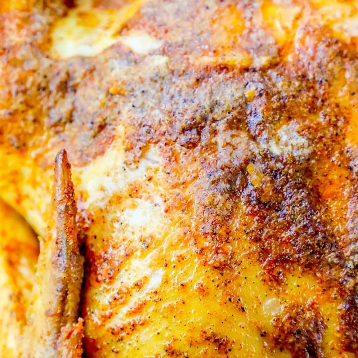 A Cajun roasted chicken on a baking sheet.