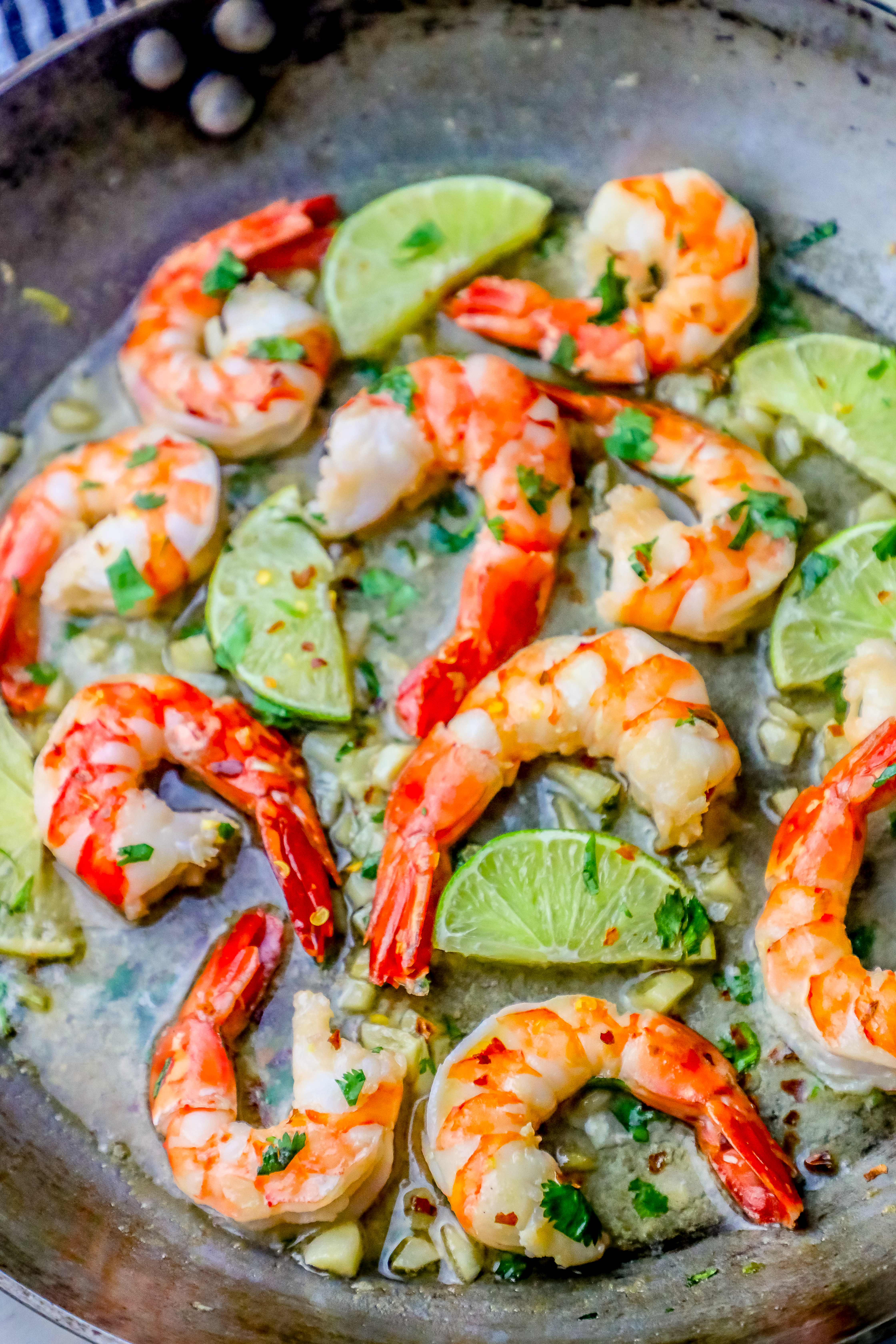 shrimp, limes, and cilantro in a pan