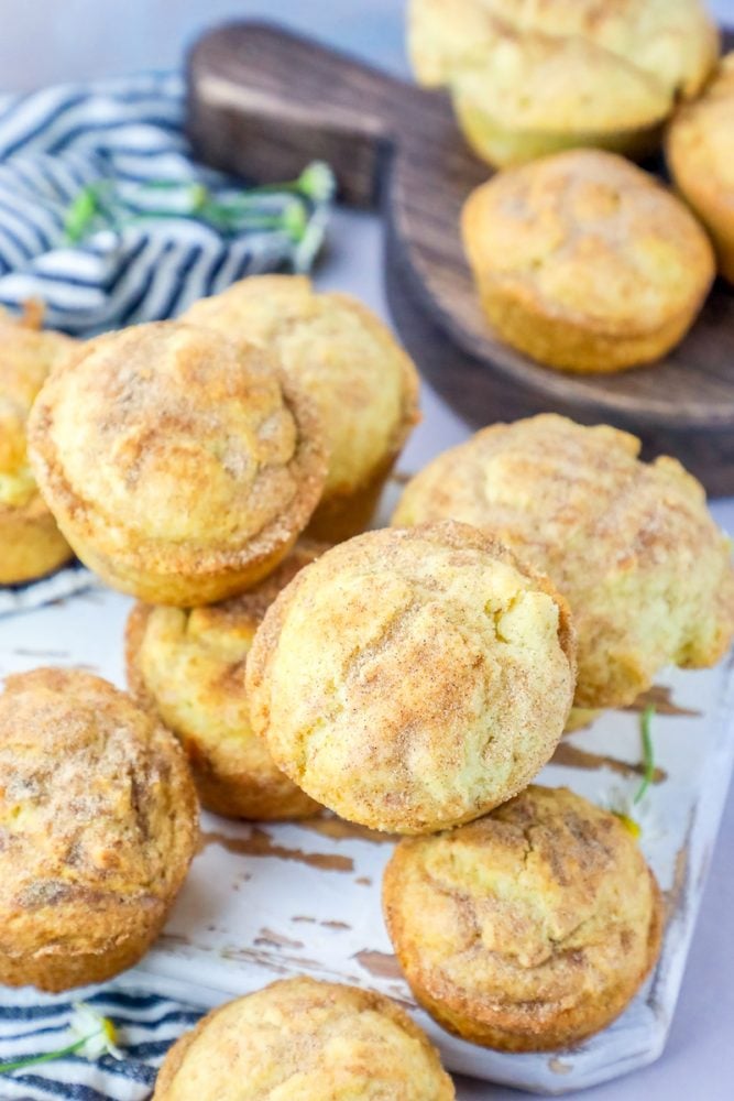 Picture of muffins covered in cinnamon sugar piled on a cutting board