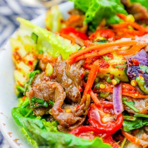A keto beef salad recipe with spicy Thai flavors, featuring lettuce and carrots.