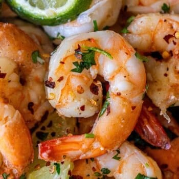 Close-up of Cilantro Lime Sautéed Shrimp garnished with chopped herbs, red pepper flakes, and lime wedges—perfect for those wanting to learn how to cook shrimp with a fresh, zesty twist.