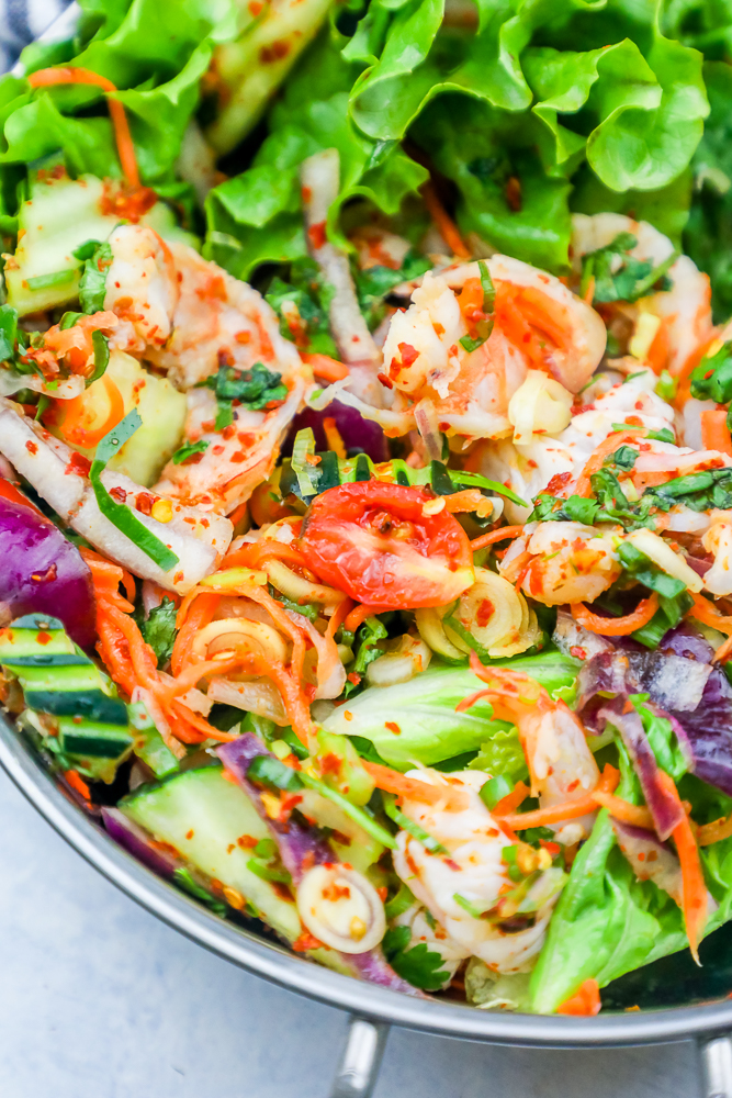 salad with shrimp, tomatoes, onions, and cucumbers in it