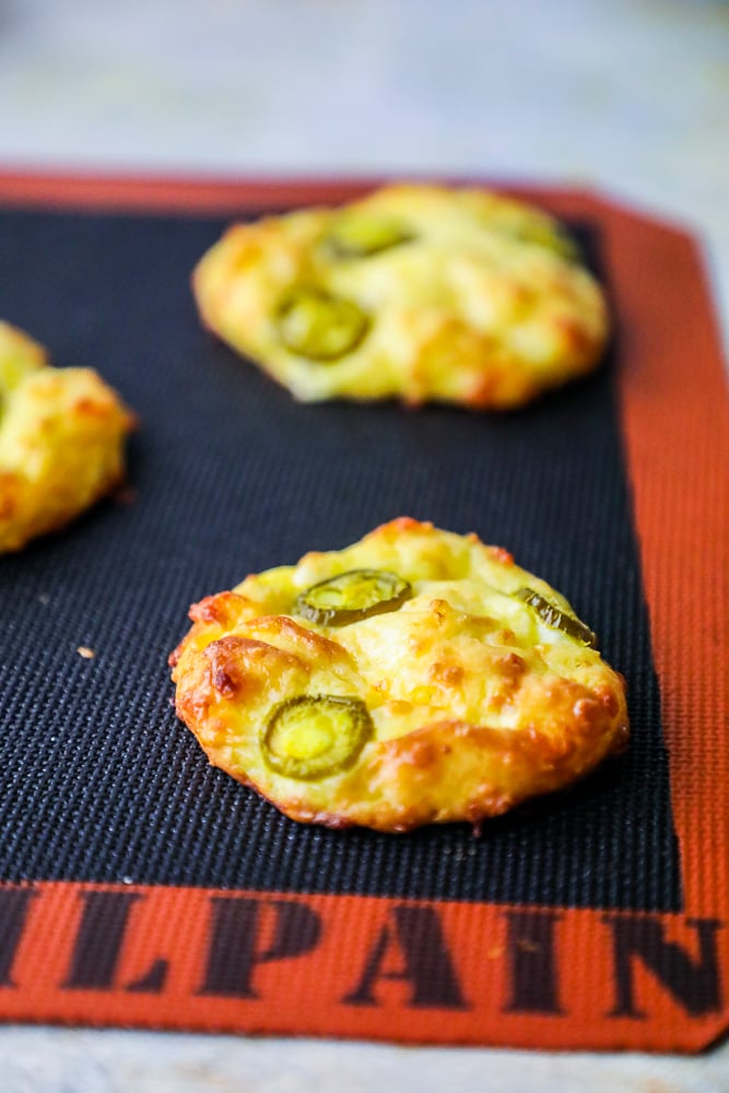 keto jalapeno keto cheese breads on a baking mat. 