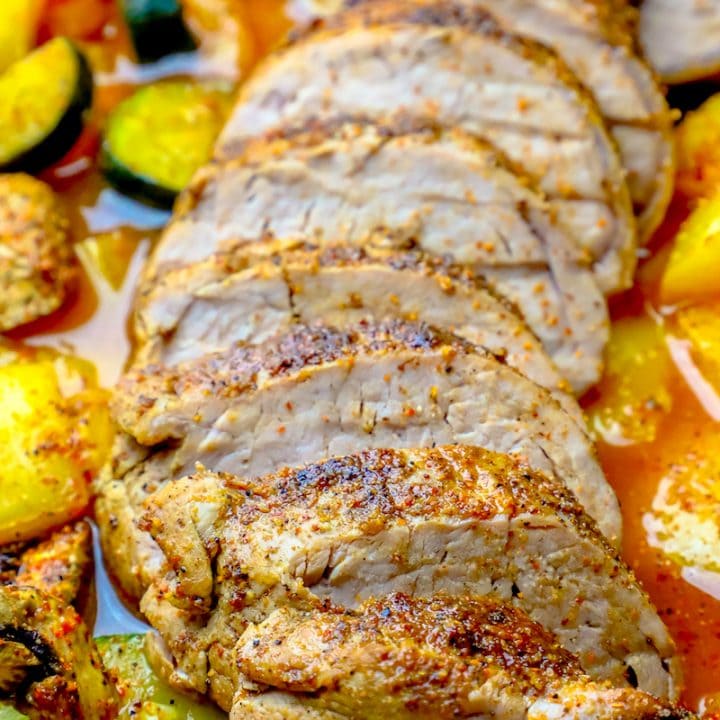 A plate with sliced pork tenderloin and vegetables on it.