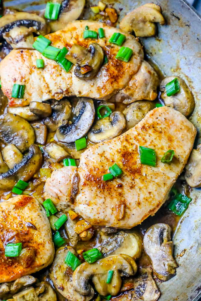 pork chops in sauce with mushrooms and green onions.