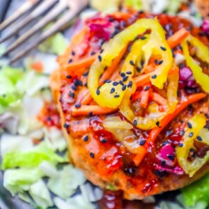 A plate of chicken burgers with vegetables and a fork, reminiscent of an easy keto salmon burger recipe.