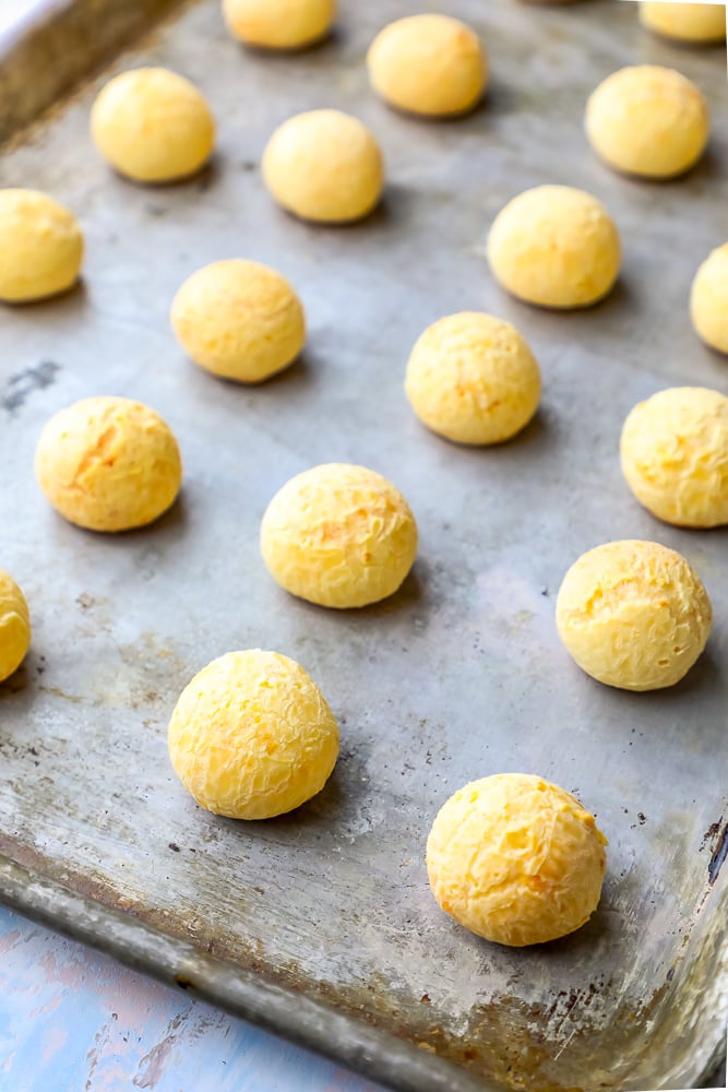 a bunch of cheese balls on a sheet pan