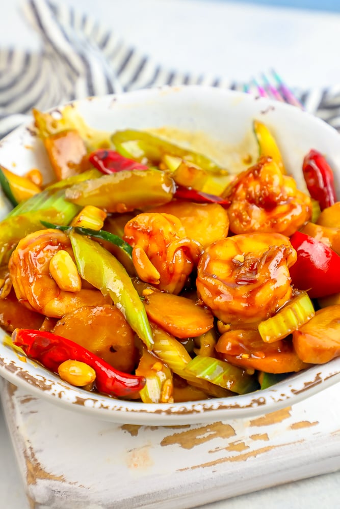 kung pao shrimp with peanuts, peppers, and vegetables in a white bowl picture