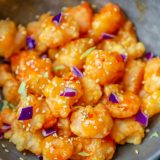 Recipe for keto bang bang shrimp, topped with sesame seeds.