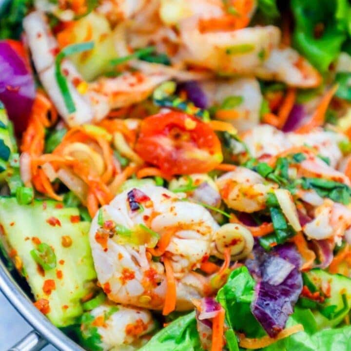 salad with shrimp, tomatoes, onions, and cucumbers in it
