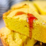 A slice of Easy Sour Cream Cornbread being drizzled with honey.
