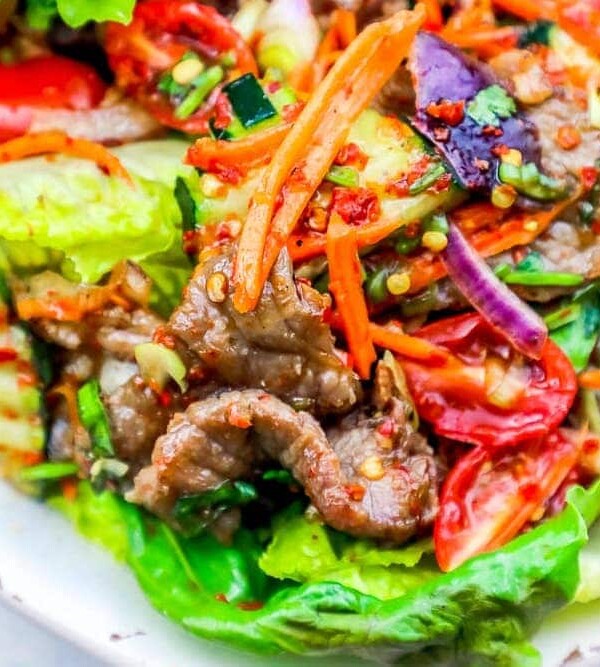 A bowl of keto spicy beef salad with carrots and lettuce.