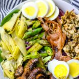 A salad bowl featuring grilled chimichurri chicken, mushrooms, and asparagus.