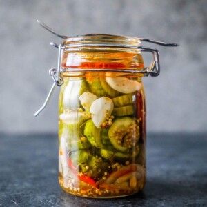 10 Minute Fridge Pickles in a glass jar on a table.