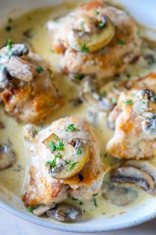 chicken thighs with mushrooms and a creamy garlic sauce in pan picture