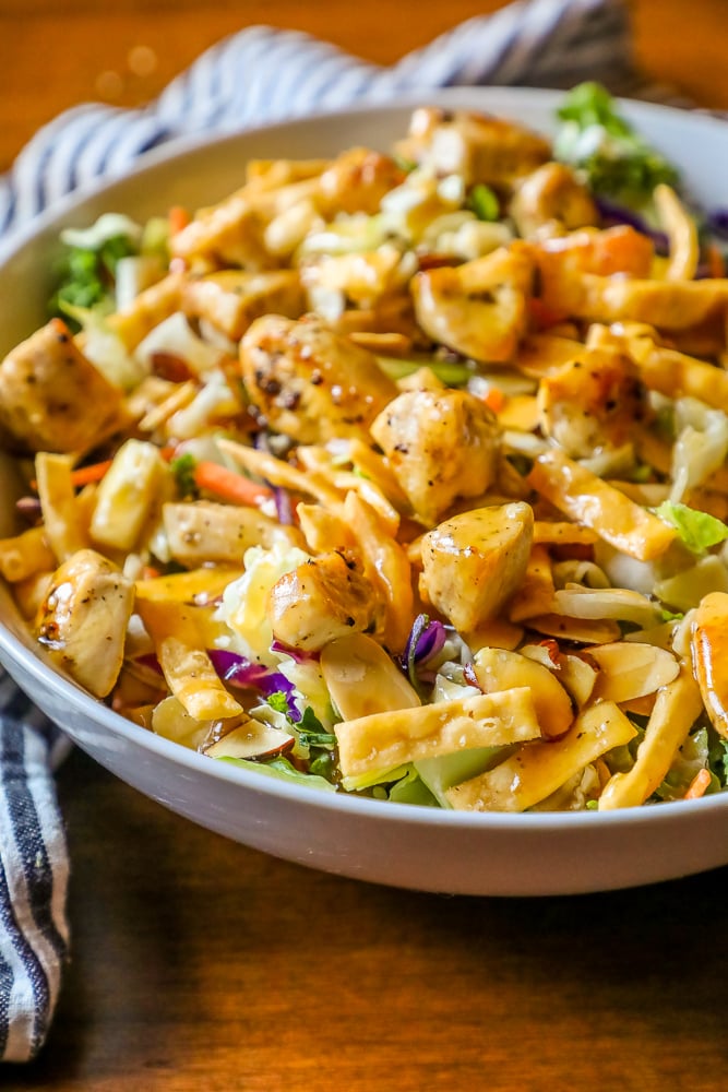 delicious chicken Asian salad in a white bowl with a striped towel in the background