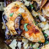 Chicken with mushrooms and parmesan cooked in a skillet.