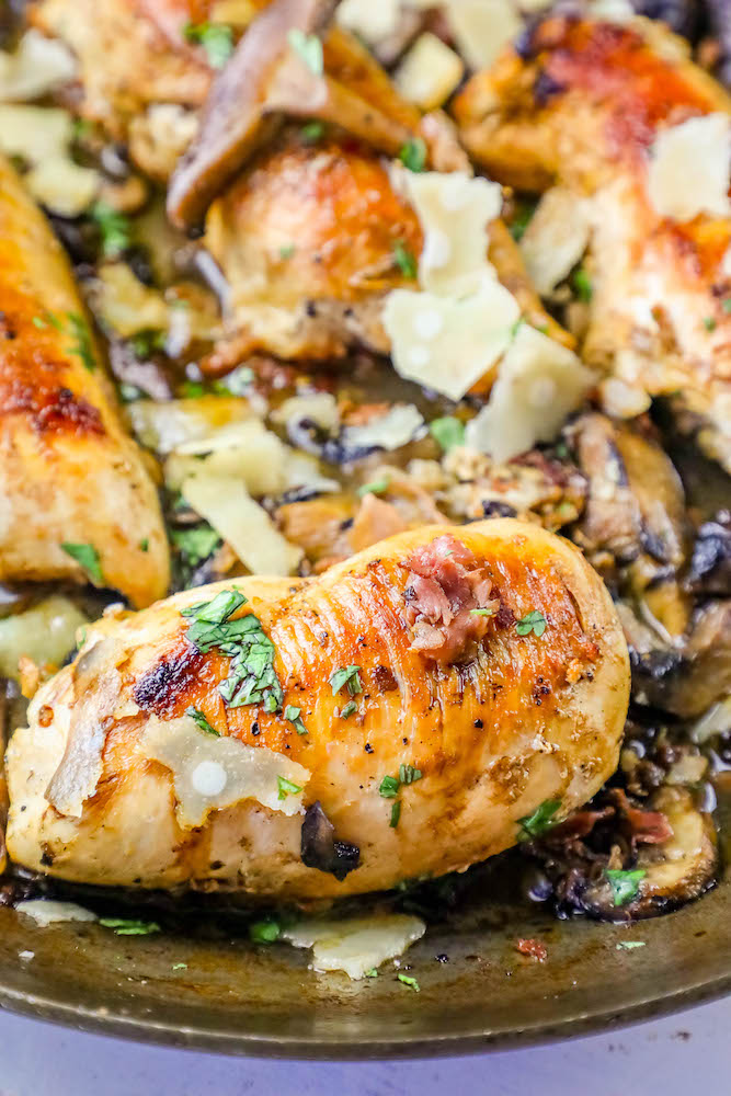 Chicken with mushrooms and parmesan cooked in a skillet.