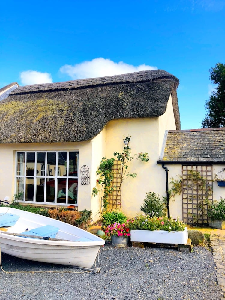 house with a thatched roof and trellis