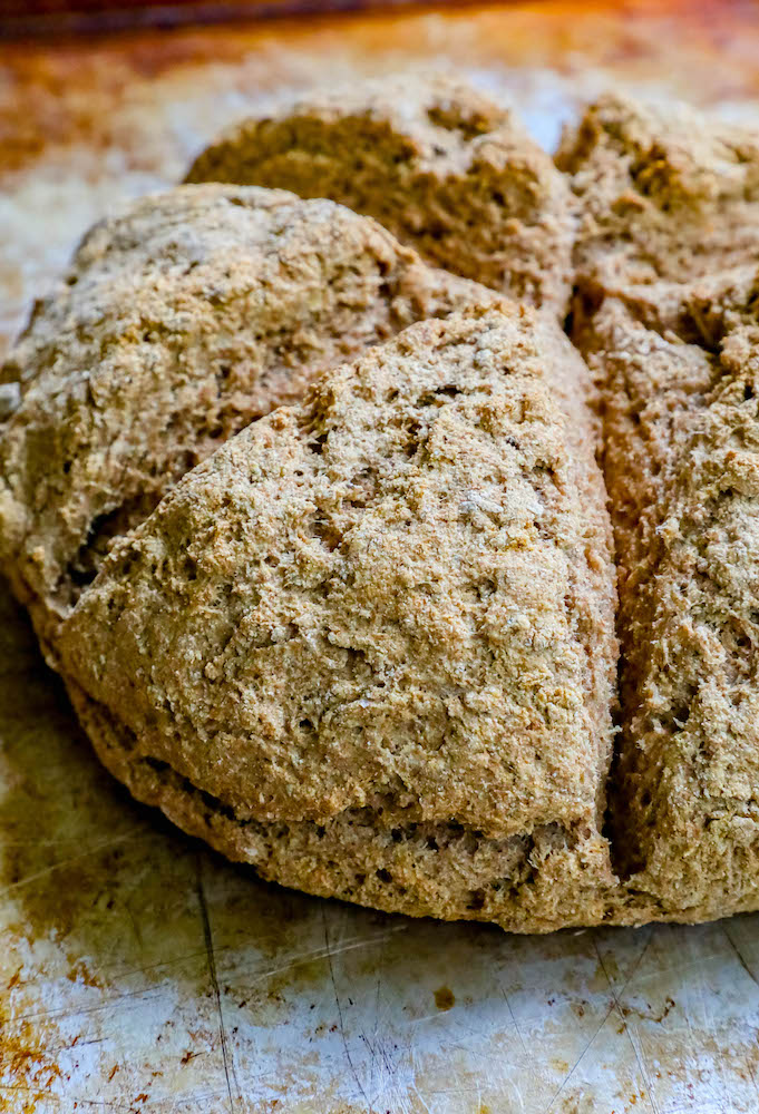 A loaf of Irish Brown Soda Bread sitting on top of a cutting board.