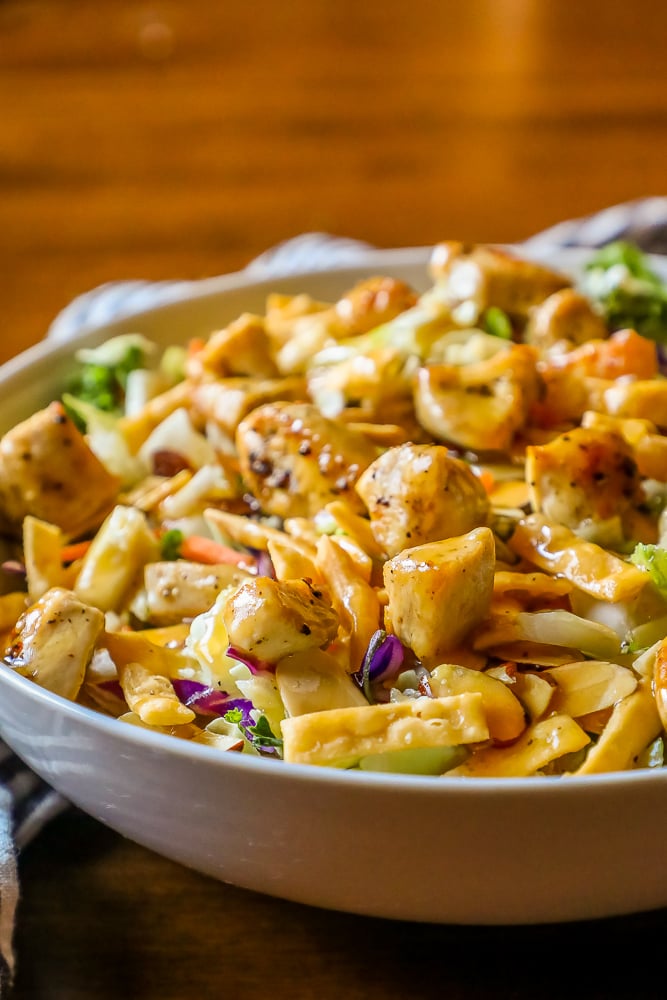 delicious chicken Asian salad in a white bowl with a striped towel in the background